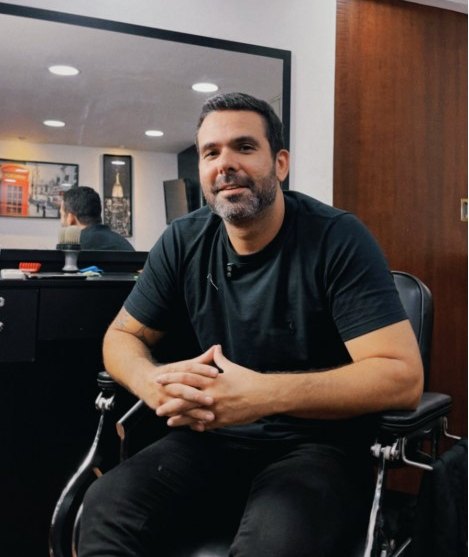 Proprietário da L&M Barbearia sentado na cadeira do salão